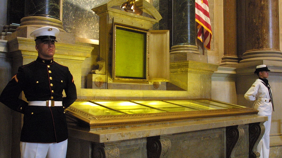 An honor guard stands next to the original copies of the Declaration of Independence, the Constitution and the Bill of Rights on July 4, 2001, at the National Archives in Washington. 