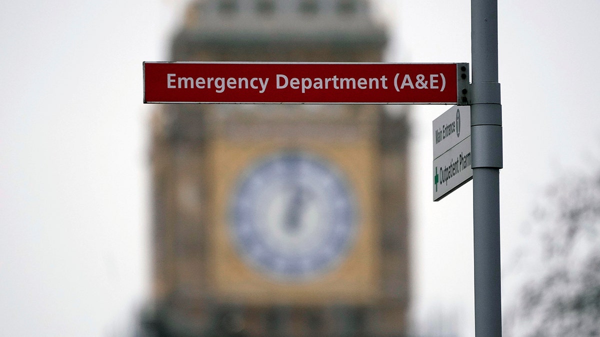 An Emergency Department sign at St Thomas' Hospital is backdropped by the Elizabeth Tower of the Houses of Parliament, known as Big Ben, in London, Thursday, Jan. 6, 2022. 