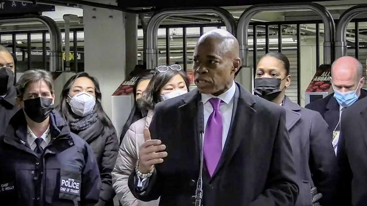 In this livestream frame grab from video provided by NYPD News, Mayor Eric Adams, foreground, with city law officials, speaks at a news conference inside a subway station after a woman was pushed to her death in front of a subway train at the Times Square station, Saturday, Jan. 15, 2022, in New York.