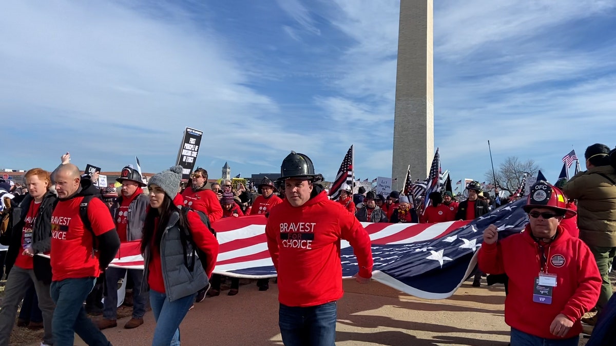 Firefighters march in the "Defeat the Mandates" rally