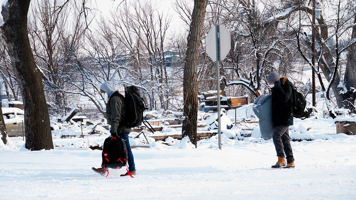 People whose homes didn’t burn in a wildfire evacuate their belongings, Saturday, Jan. 1, 2022, in Superior, Colorado.