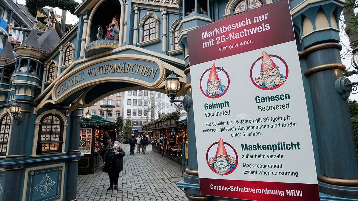 A sign at a winter market in Cologne, Germany, demands a mandatory mask and the 2G rule, that means only vaccinated or recovered customers are allowed to enter, Friday, Jan. 7, 2022.