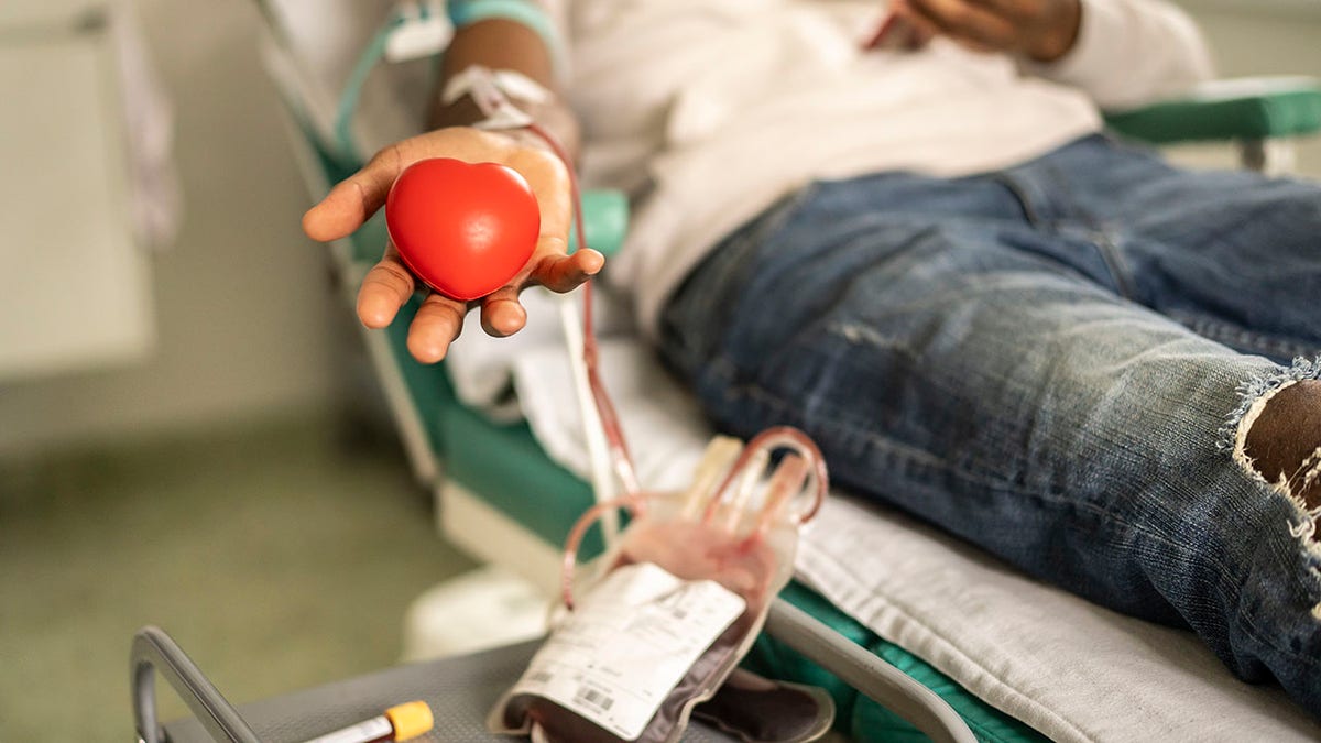 Donor squeezing the heart-shaped ball during blood donation