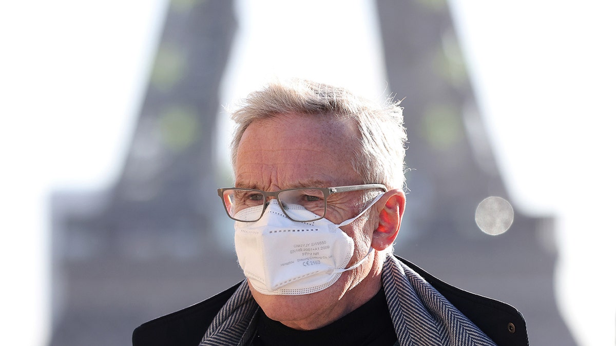 A man wearing a face mask walks at the Trocadero Place near the Eiffel Tower in Paris, France, Jan. 5, 2022. 