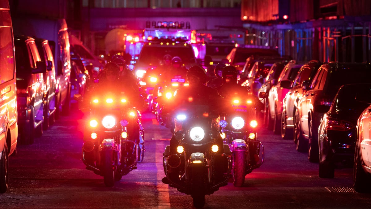 NYPD officers in motorcycles lead an ambulance carrying Officer Wilbert Mora as he is transferred from Harlem Hospital to NYU Langone hospital on Sunday, Jan. 23, 2022. (AP Photo/Yuki Iwamura)