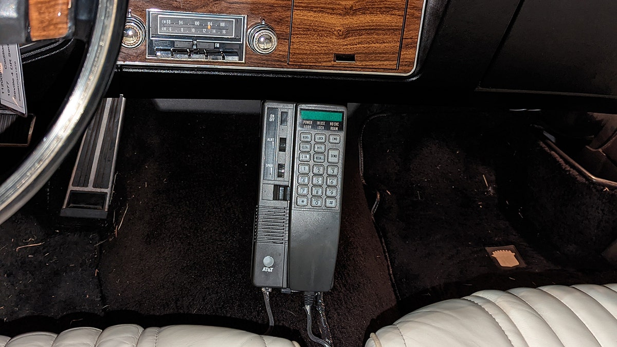 White's Cadillac is equipped with an AT&T mobile phone.