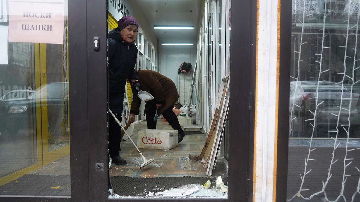 Vendors clean their store that was broken into and looted during clashes in Almaty, Kazakhstan.