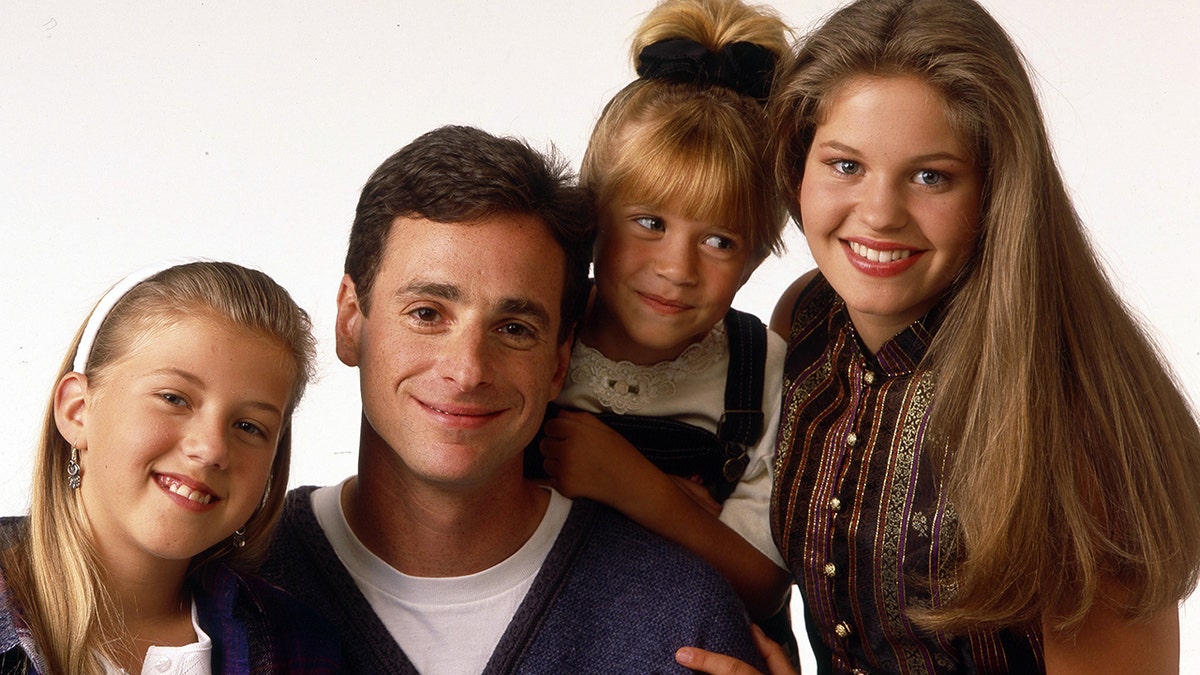 From l-r: Jodie Sweetin as Stephanie Tanner, Bob Saget as Danny Tanner, Mary-Kate or Ashley Olsen as Michelle Tanner and Candace Cameron Bure as D.J. Tanner in "Full House."