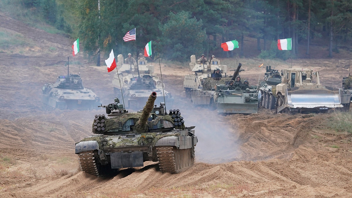 Military vehicles and tanks of Poland, Italy, Canada and United States roll during the NATO military exercises ''Namejs 2021'' at a training ground in Kadaga, Latvia, Sept. 13, 2021. 