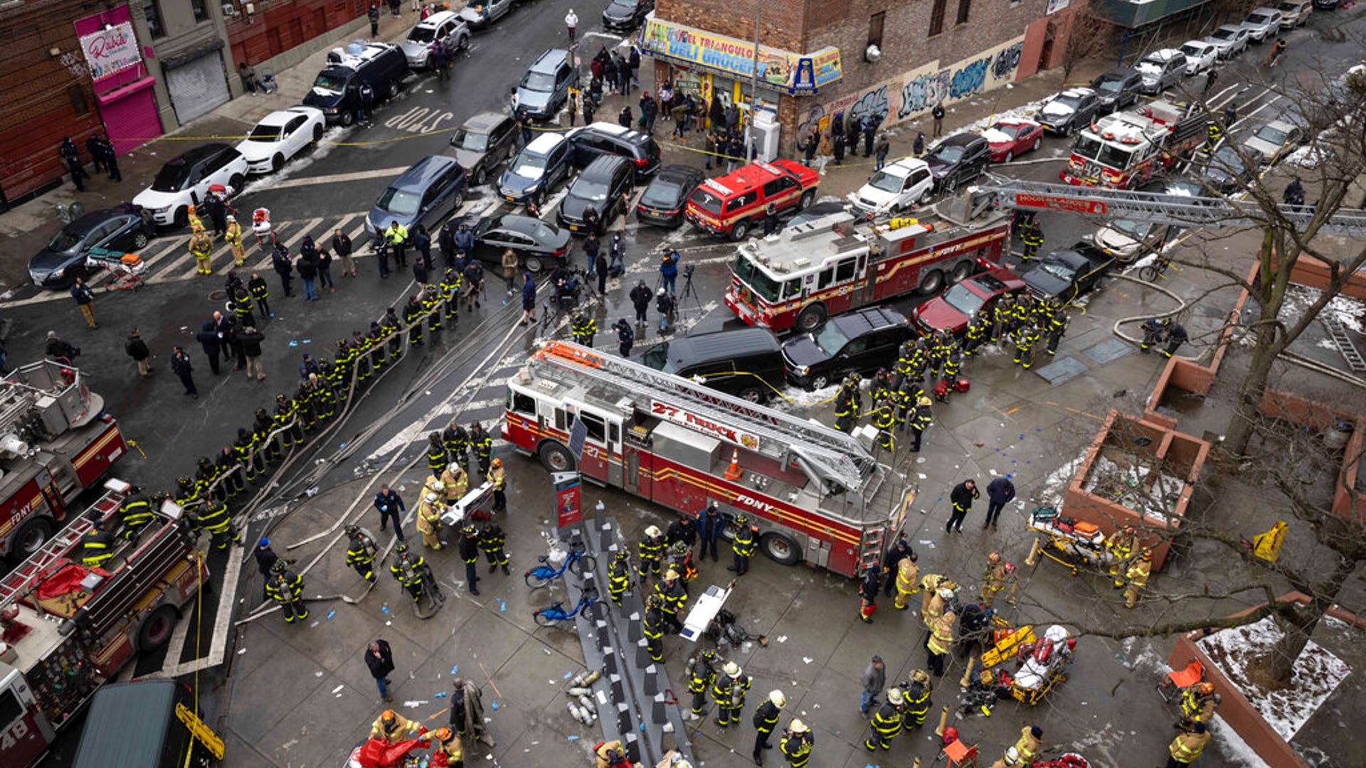 Firefighters work outside an apartment building after a fire in the Bronx