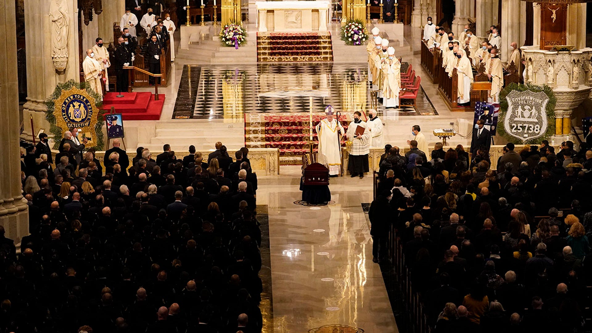 Cardinal Timothy Dolan blesses the casket of NYPD Officer Jason Rivera during Rivera's funeral service, Friday, Jan. 28, 2022, at St. Patrick's Cathedral in New York. (AP Photo/Mary Altaffer)