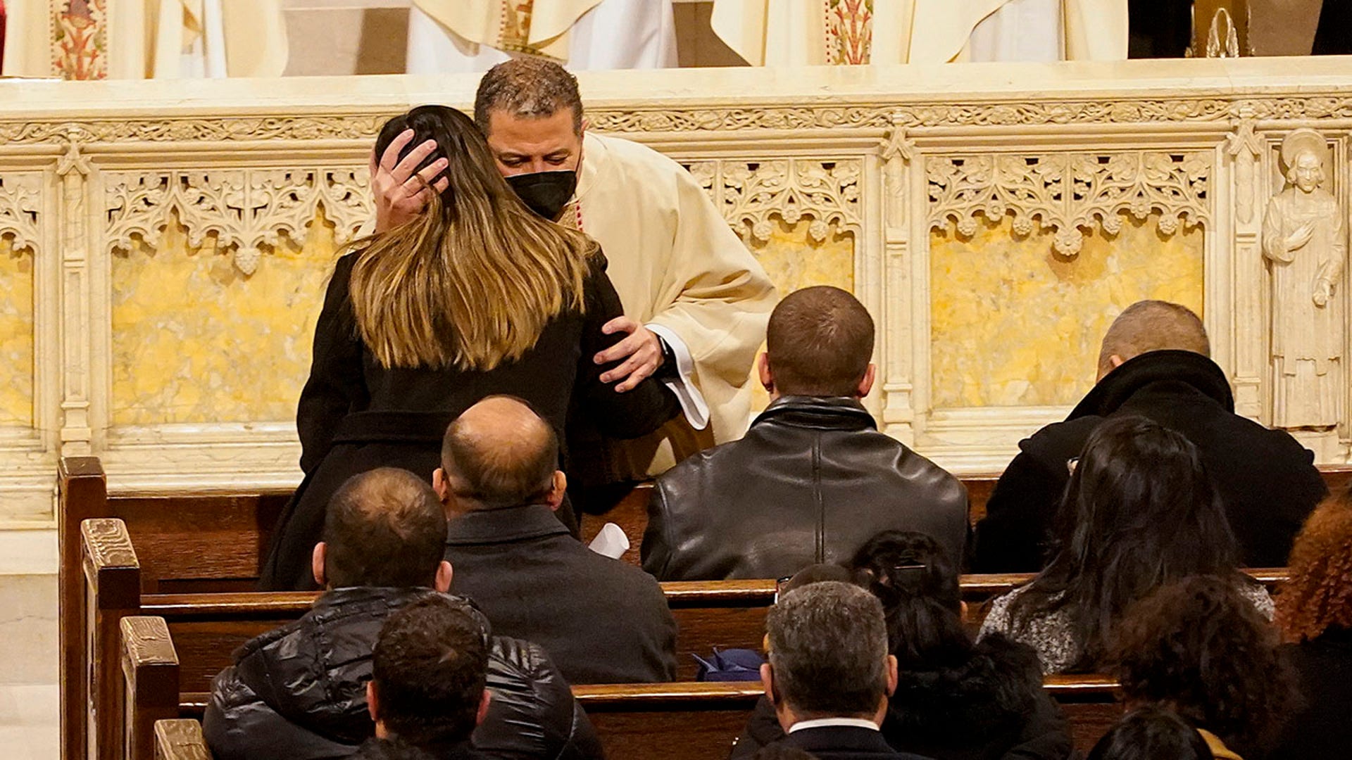 A priest hugs Dominique Rivera, the wife of NYPD Officer Jason Rivera during funeral services for Rivera, Friday, Jan. 28, 2022, at St. Patrick's Cathedral in New York.  (AP Photo/Mary Altaffer, POOL)