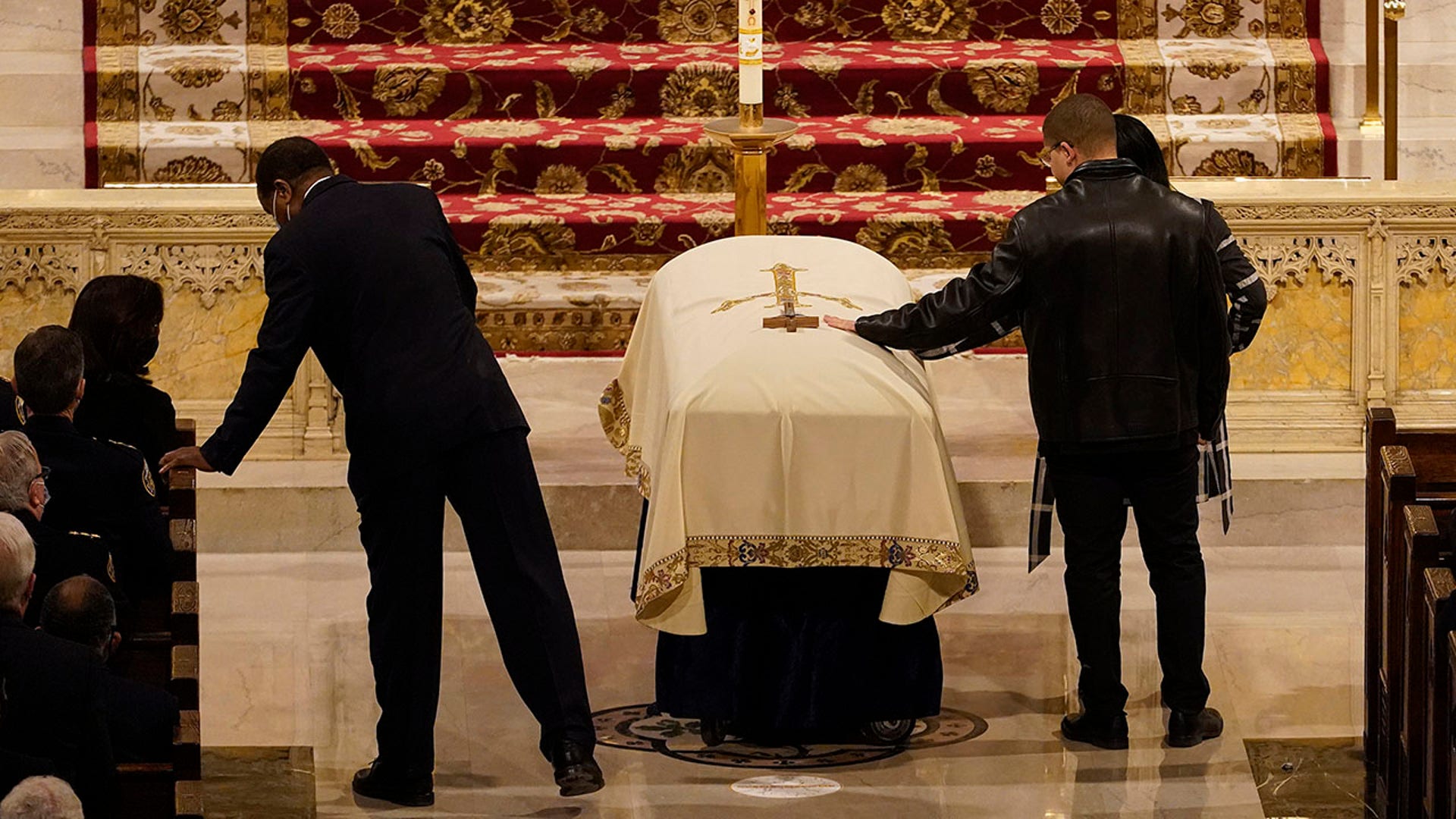Family members touch the casket during a funeral service for NYPD officer Jason Rivera Friday, Jan. 28, 2022, at St. Patrick's Cathedral in New York. Rivera and his partner, Officer Wilbert Mora, were fatally shot when a gunman ambushed them in an apartment as they responded to a family dispute last week. (AP Photo/Mary Altaffer, POOL)