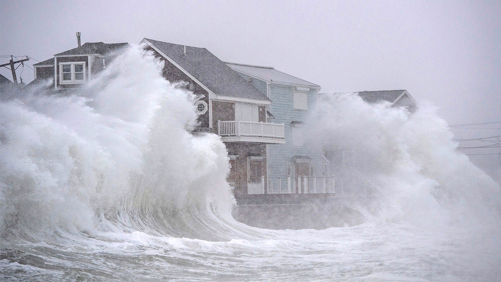 Waves crash over oceanfront homes during a noreaster in Scituate, Massachusetts on January 29, 2022.