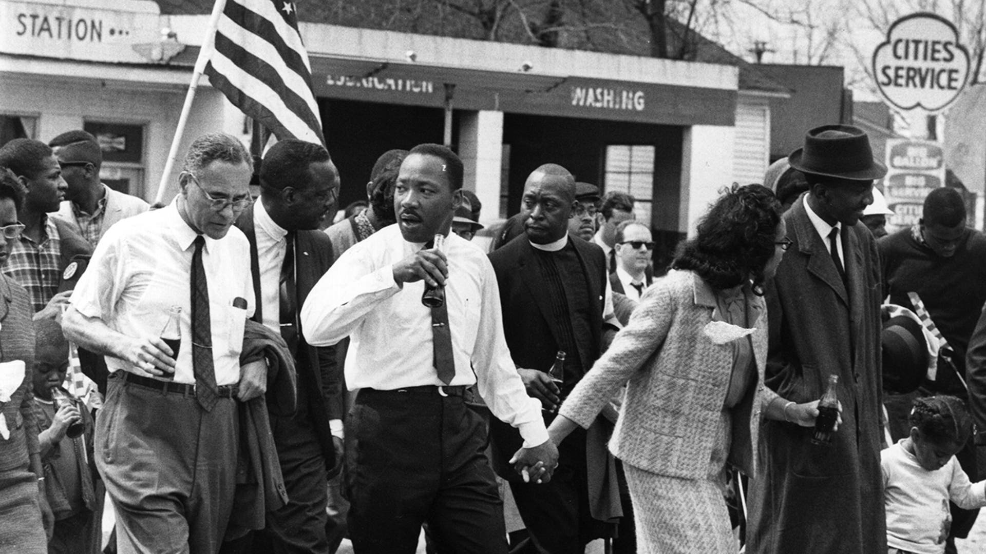 Martin Luther King Jr. and his wife, Coretta Scott King, lead a civil rights march from Selma, Alabama, to the state capital in Montgomery. On the left (holding bottle) is American diplomat Ralph Bunche.
