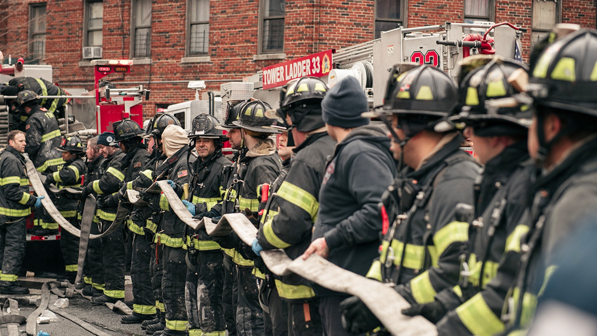 Firefighters work outside an apartment building after a fire in the Bronx
