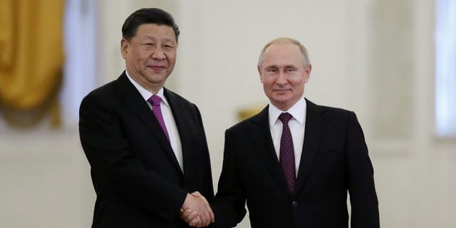 Vlagyimir Putyin orosz elnök kezet fog kínai kollégájával, Hszi Csin-pinggel a Kremlben Moszkvában