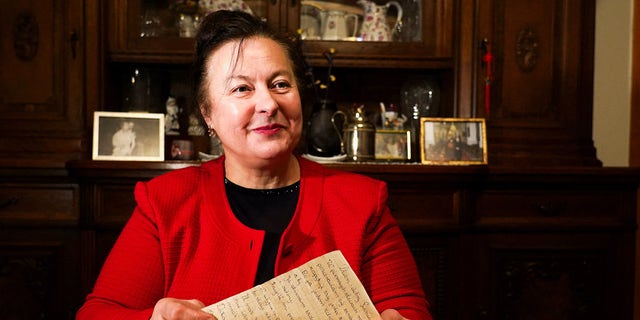Letter recipient Genowefa Klonowska holds a letter received around 50 years later in Vilnius, Lithuania, January 25, 2022.
