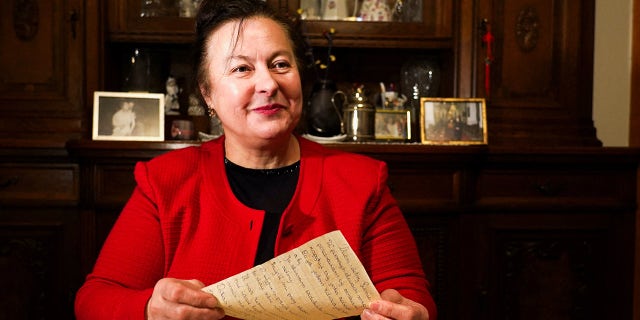 Letter recipient Genowefa Klonowska holds a letter received around 50 years later in Vilnius, Lithuania, January 25, 2022.