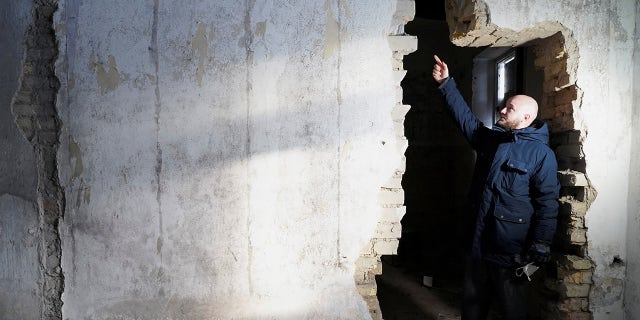 Building owner Jurgis Vilutis shows a hole in the wall where the letters were found in the former post office building in Vilnius, Lithuania.