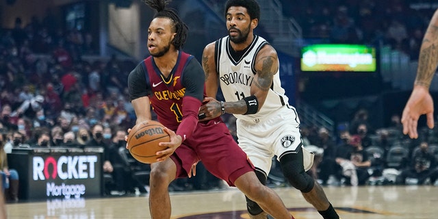 Cleveland Cavaliers' Darius Garland, left, drives against Brooklyn Nets' Kyrie Irving (11) in the first half of an NBA basketball game, Monday, Jan. 17, 2022, in Cleveland.