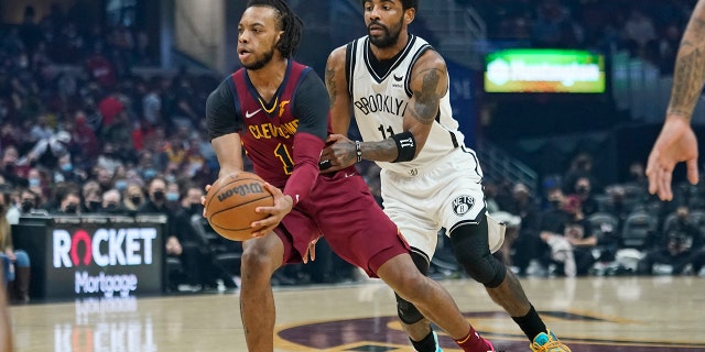 Cleveland Cavaliers' Darius Garland, links, drives against Brooklyn Nets' Kyrie Irving (11) in the first half of an NBA basketball game, Maandag, Jan.. 17, 2022, in Cleveland.