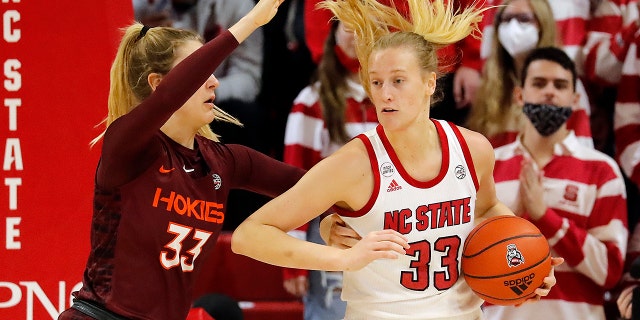 Virginia Tech's Elizabeth Kitle , left, battles with North Carolina State's Elissa Cunane, right, during the first half of an NCAA college basketball game, Sunday, Jan. 23, 2022, in Raleigh, N.C.