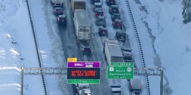 Em 4 de janeiro de 2022, veículos são vistos em uma imagem estática de vídeo enquanto as autoridades trabalham para reabrir a seção gelada da Interestadual 95 perto de Garrisonville, Virgínia.  (Reuters)