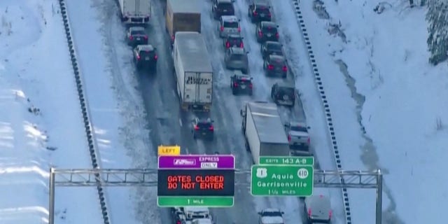 On Jan. 4, 2022, vehicles are seen in a still image from video as authorities work to reopen the icy section of Interstate 95 near Garrisonville, Virginia.  (Reuters)