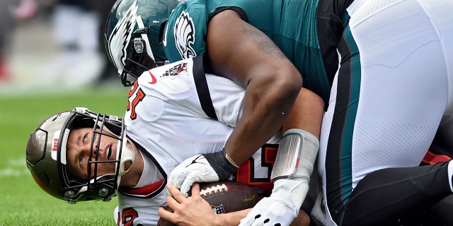 탬파베이 버커니어스 쿼터백 톰 브래디 (12) gets sacked by Philadelphia Eagles defensive tackle Javon Hargrave during the first half of an NFL wild-card football game Sunday, 1 월. 16, 2022, 탬파, Fla.