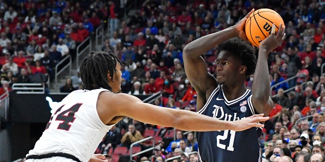 Duke forward A.J. Griffin (21) attempts to pass over Louisville forward Jae'Lyn Withers (24) during the first half of an NCAA college basketball game in Louisville, Ky., Saturday, Jan. 29, 2022.