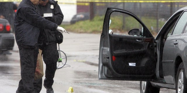 Detroit police investigate a shooting. Law enforcement leaders this week said homicides, non-fatal shootings and robberies were down in 2021.
