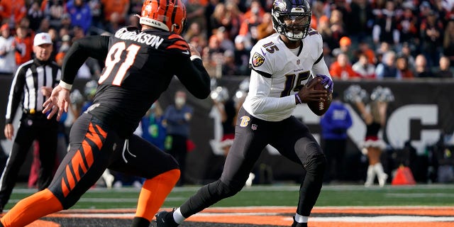 Baltimore Ravens' Josh Johnson (15) looks to throw against Cincinnati Bengals' Trey Hendrickson (91) during the fist half of an NFL football game, 星期日, 十二月. 26, 2021, 在辛辛那提.