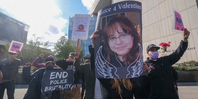 People hold signs with pictures of Valentina Orellana-Peralta during a news conference outside the Los Angeles Police Department headquarters in Los Angeles on Dec. 28, 2021.