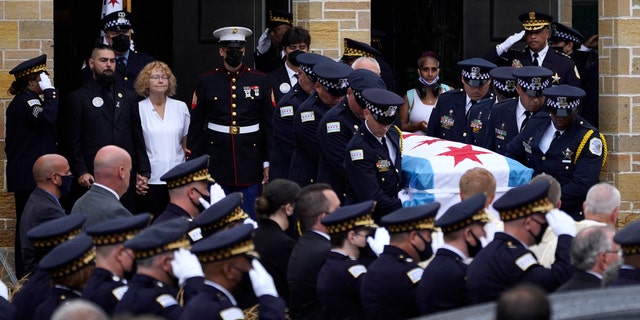 Elizabeth French, in white, and her son Andrew, left, follow the casket of her daughter, Chicago police officer Ella French, after a funeral service at the St. Rita of Cascia Shrine Chapel Thursday, Aug. 19, 2021, in Chicago.(AP Photo/Charles Rex Arbogast, File)