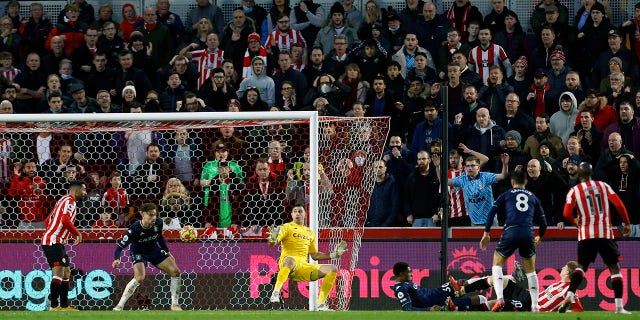 Brentford's Mads Roerslev, on ground at right, scores his side's second goal of the game, during the English Premier League soccer match between Brentford and Aston Villa, at the Brentford Community Stadium, in London, Sunday, Jan. 2, 2022.