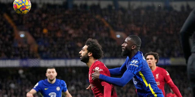 Liverpool's Mohamed Salah and Chelsea's Antonio Rudiger, right, battle for the ball during the English Premier League soccer match between Chelsea and Liverpool at Stamford Bridge in London, Sunday, Jan. 2, 2022.