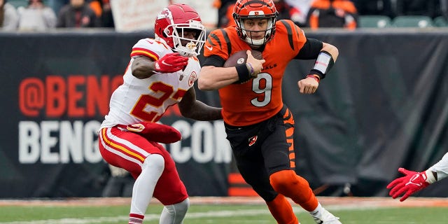 Cincinnati Bengals quarterback Joe Burrow (9) scrambles against Kansas City Chiefs cornerback Rashad Fenton (27) during the first half of an NFL football game, Sunday, Jan. 2, 2022, in Cincinnati.
