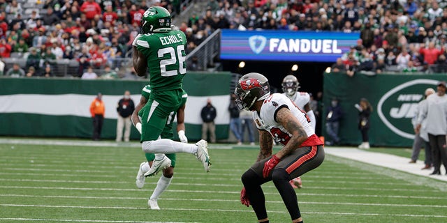 New York Jets' Brandin Echols, left, intercepts a pass intended for Tampa Bay Buccaneers' Mike Evans during the first half of an NFL football game, Sunday, Jan. 2, 2022, in East Rutherford, New Jersey.