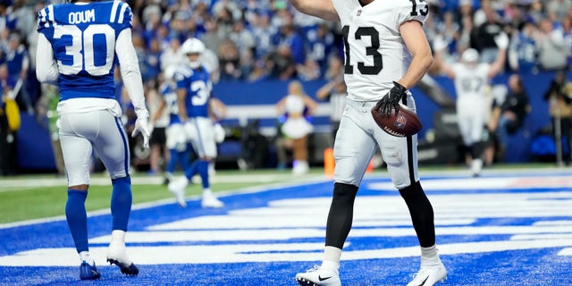 Las Vegas Raiders receiver Hunter Renfrow (13) celebrates in front of Indianapolis Colts safety George Odum (30) after catching an 11-yard touchdown pass during the second half of a game Jan. 2, 2022, in Indianapolis.