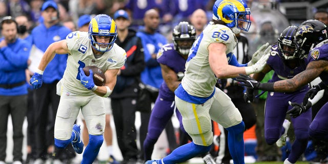 Los Angeles Rams wide receiver Cooper Kupp, izquierda, runs with the ball after making a catch against the Baltimore Ravens during the second half of an NFL football game, domingo, ene. 2, 2022, in Baltimore. On the play, Kupp broke the Rams' franchise single season record for most receiving yards after surpassing Isaac Bruce's 1,781 yards set in 1995.
