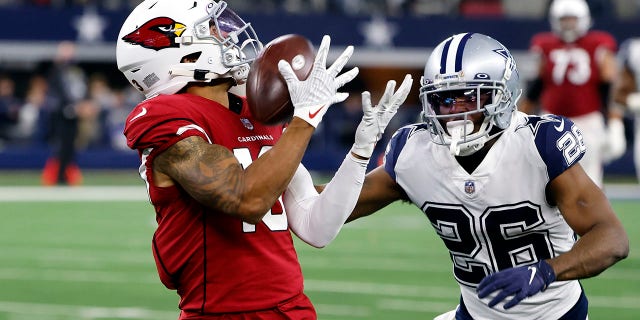 Arizona Cardinals wide receiver Christian Kirk catches a pass for a first down as Dallas Cowboys cornerback Jourdan Lewis defends during the second half of an NFL football game Sunday, Jan. 2, 2022, in Arlington, Texas.