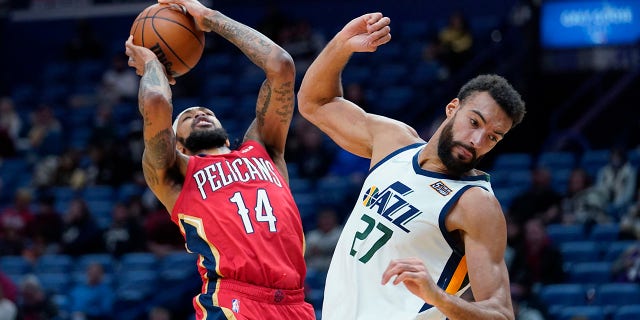 New Orleans Pelicans forward Brandon Ingram (14) shoots against Utah Jazz center Rudy Gobert (27) in the first half of an NBA basketball game in New Orleans, 星期一, 一月. 3, 2022.