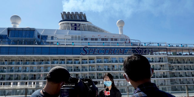 Journalists film the Spectrum of the Seas cruise ship which is docked at Kai Tak cruise terminal in Hong Kong Wednesday, Jan. 5, 2022. (AP Photo/Vincent Yu)