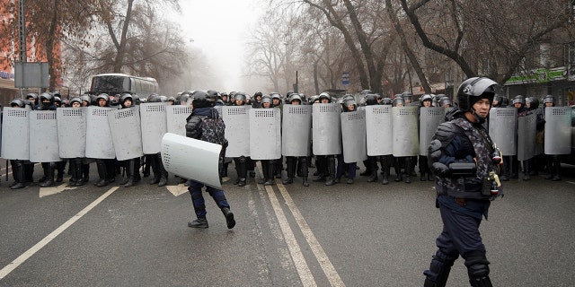 Riot police officers stand ready to stop demonstrators during a protest in Almaty, Kazakhstan, Wednesday, Jan. 5, 2022. (AP Photo/Vladimir Tretyakov)