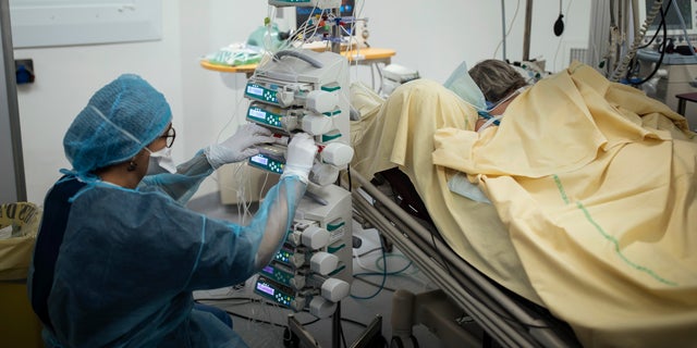 A nurse cares for a patient inside an operating room now used for COVID-19 patients at Bichat Hospital, AP-HP, in Paris, April 22, 2021. (AP Photo/Lewis Joly, File)