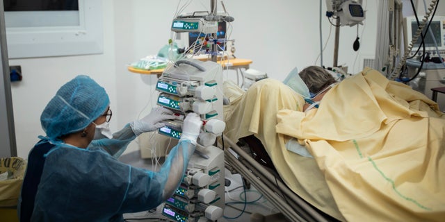 A nurse cares for a patient inside an operating room now used for COVID-19 patients at Bichat Hospital, AP-HP, in Paris, April 22, 2021. (AP Photo/Lewis Joly, File)