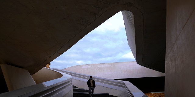 A man wearing a face mask walks down the stairs at Elephteria, Liberty, Square in central Nicosia, Cyprus, on Wednesday, January 5, 2022. (Associated Press)