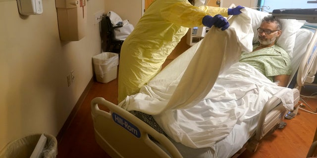 Registered nurse Rachel Chamberlin, of Cornish, N.H., left, tends to COVID-19 patient Fred Rutherford, of Claremont, N.H. (AP Photo/Steven Senne)