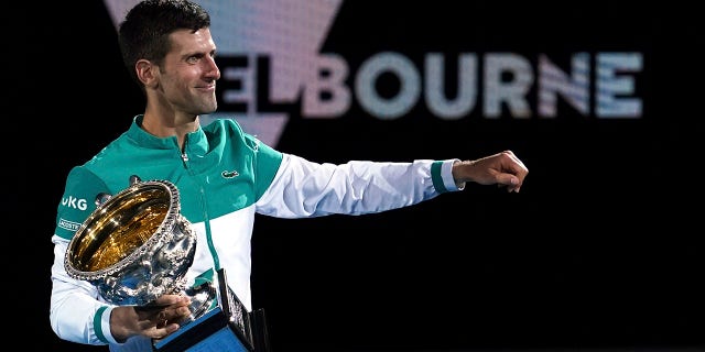 Serbia's Novak Djokovic holds the Norman Brookes Challenge Cup after defeating Russia's Daniil Medvedev in the men's singles final at the Australian Open tennis championship in Melbourne, Australia, Sunday, Feb. 21, 2021. 